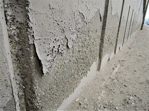 Deterioration of a coating on concrete, as well as the concrete underneath, due to capillary water penetration